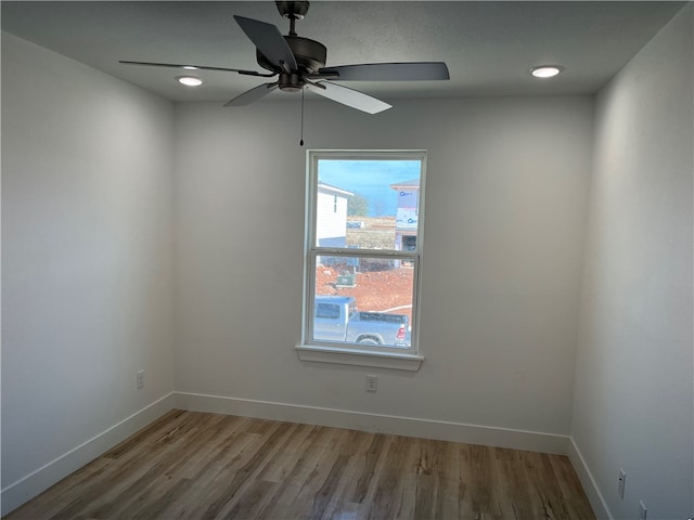 empty room featuring plenty of natural light, ceiling fan, and light wood-type flooring