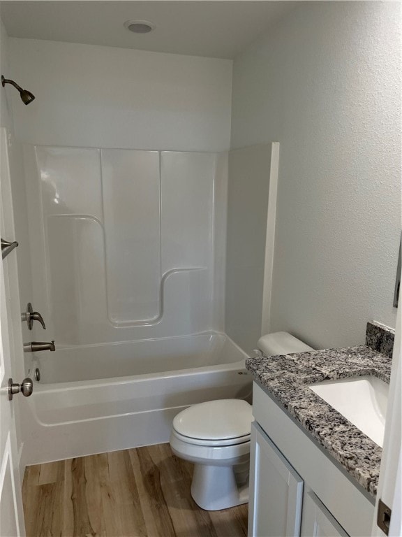 full bathroom with shower / washtub combination, vanity, toilet, and hardwood / wood-style flooring