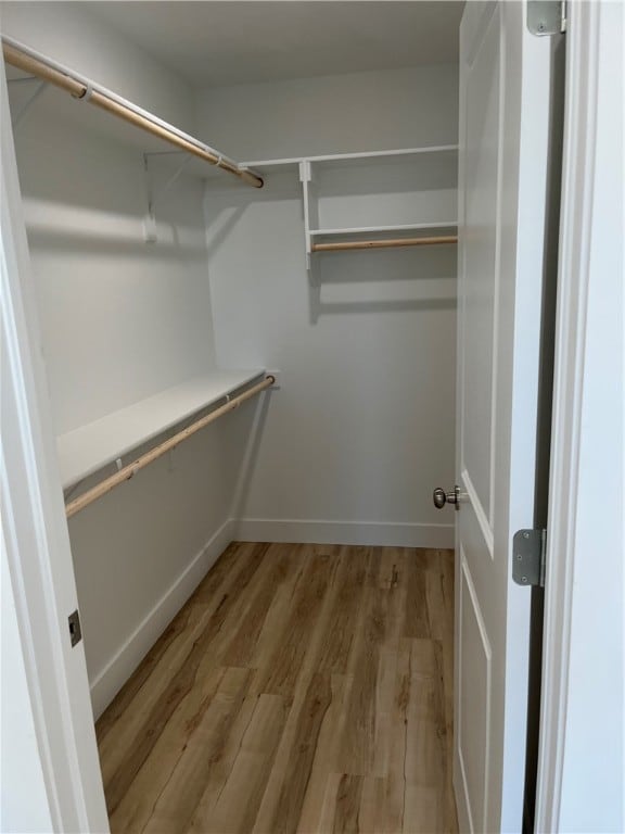 spacious closet with light hardwood / wood-style flooring