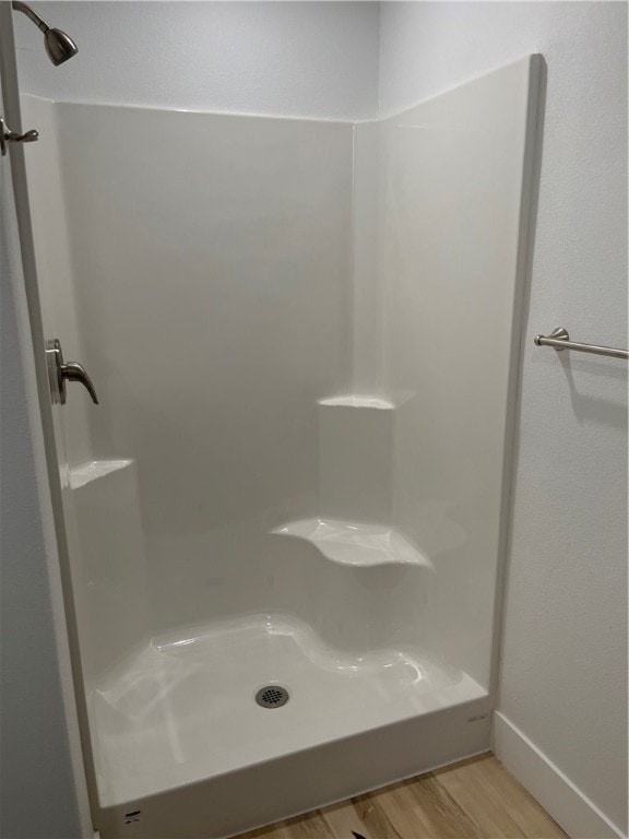 bathroom with a shower and wood-type flooring