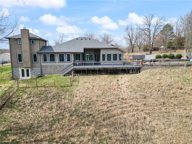 back of property with a deck and a yard