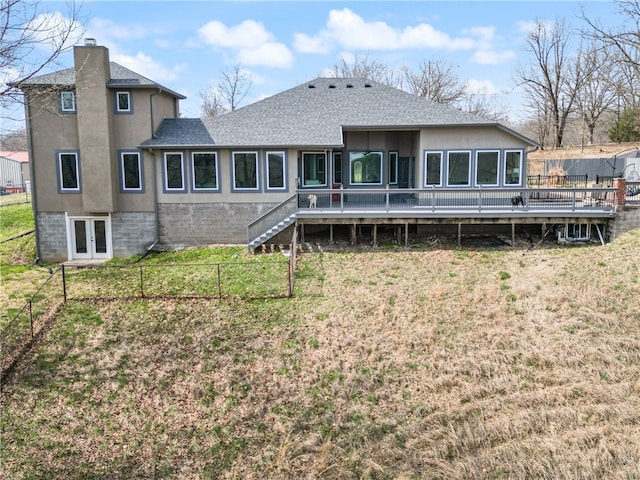 rear view of house featuring a deck and a yard