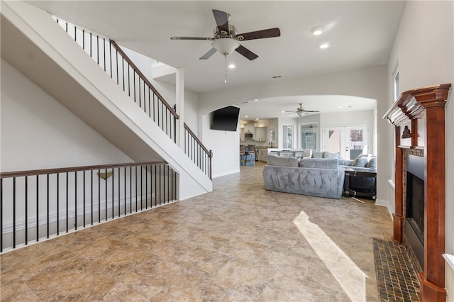 unfurnished living room featuring ceiling fan