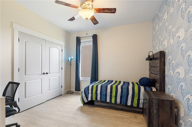 bedroom featuring ceiling fan, a closet, and light hardwood / wood-style floors