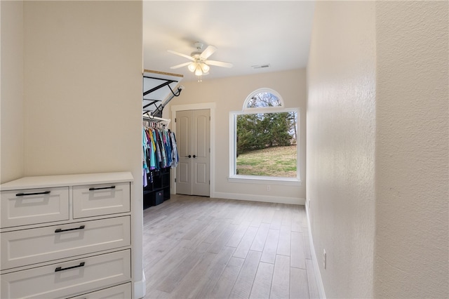 walk in closet with light hardwood / wood-style flooring and ceiling fan