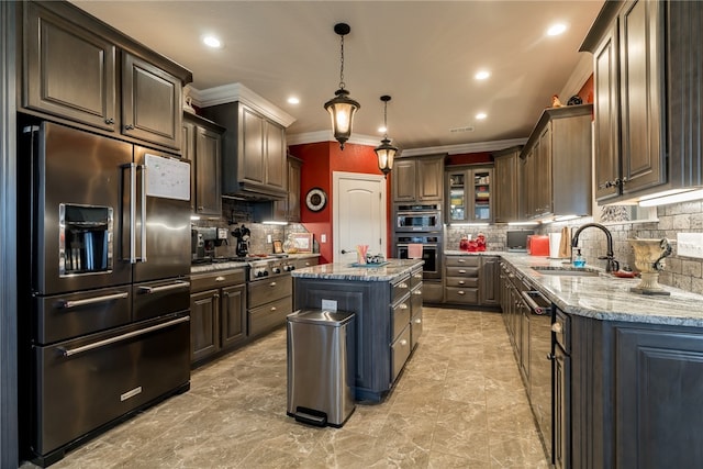 kitchen with sink, stainless steel appliances, a center island, tasteful backsplash, and pendant lighting