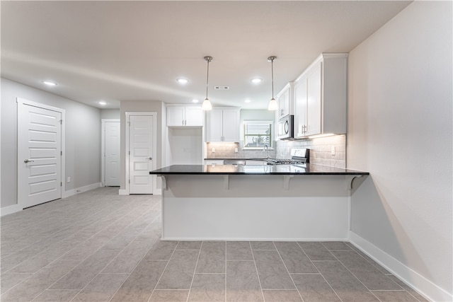 kitchen featuring range, white cabinetry, light tile floors, tasteful backsplash, and pendant lighting