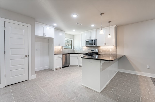 kitchen featuring appliances with stainless steel finishes, white cabinetry, light tile floors, kitchen peninsula, and hanging light fixtures