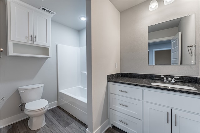 full bathroom featuring washtub / shower combination, toilet, large vanity, and hardwood / wood-style flooring