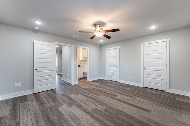 unfurnished bedroom featuring dark hardwood / wood-style floors, ceiling fan, and ensuite bath