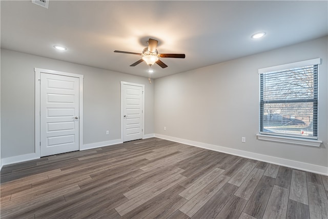 empty room with ceiling fan and dark hardwood / wood-style flooring