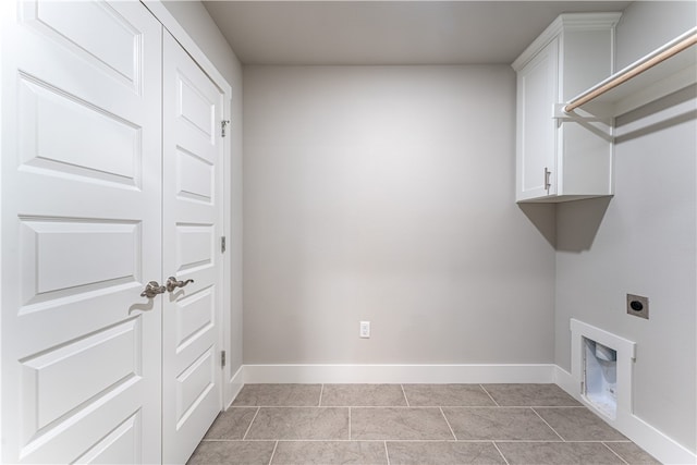 laundry room with cabinets, hookup for an electric dryer, and light tile floors