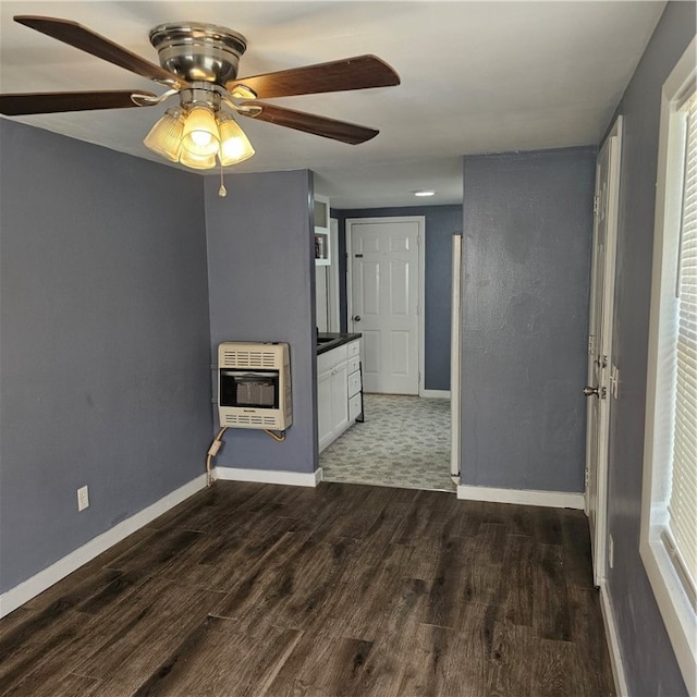 unfurnished living room with heating unit, ceiling fan, and dark hardwood / wood-style flooring