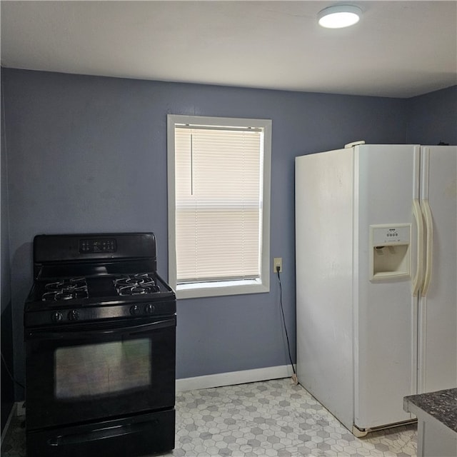 kitchen featuring white refrigerator with ice dispenser and black range with gas stovetop