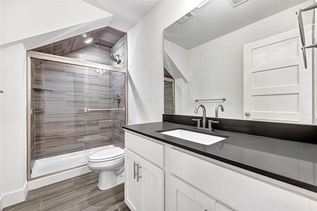 full bathroom featuring vanity, a shower stall, toilet, and visible vents