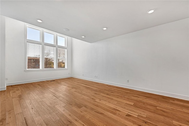 empty room with recessed lighting, baseboards, and light wood finished floors