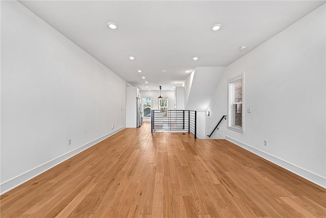 unfurnished room with recessed lighting, light wood-type flooring, and baseboards