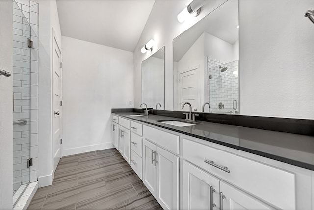 bathroom with a shower with door, lofted ceiling, and vanity