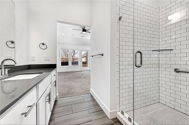 bathroom featuring vanity, ceiling fan, and a shower with door