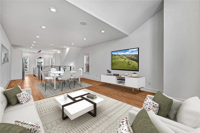 living area with recessed lighting, baseboards, and light wood finished floors