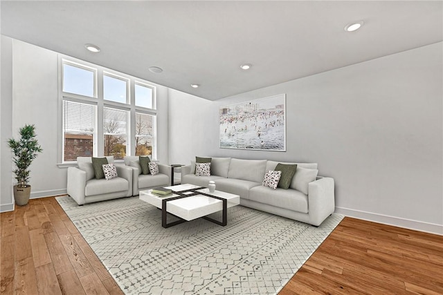 living area with recessed lighting, light wood-style floors, and baseboards