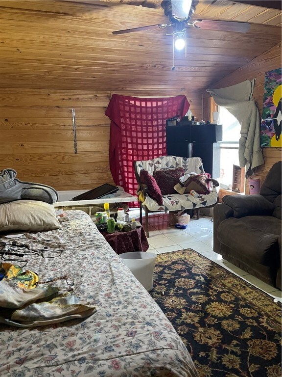 18995 Skylight Mountain Rd, Canehill, AR 72717 - bedroom featuring ceiling fan, wood walls, wood ceiling, and light tile floors