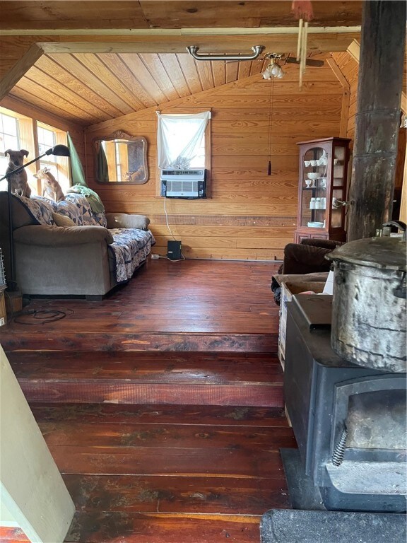 18995 Skylight Mountain Rd, Canehill, AR 72717 - bedroom with a wood stove, dark wood-type flooring, and vaulted ceiling