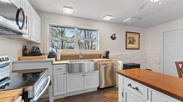 kitchen with white cabinets, butcher block counters, sink, and appliances with stainless steel finishes