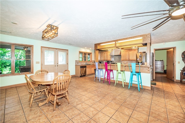 tiled dining space with ceiling fan, french doors, and a textured ceiling