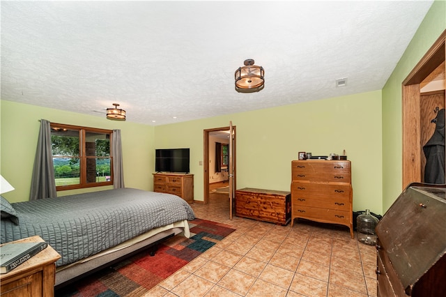 tiled bedroom featuring a textured ceiling