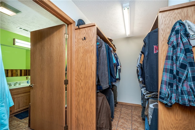 walk in closet featuring sink and tile floors