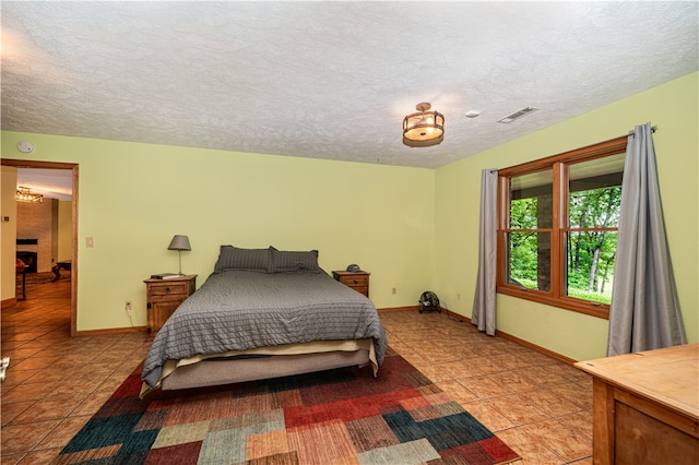 bedroom with a textured ceiling and tile floors