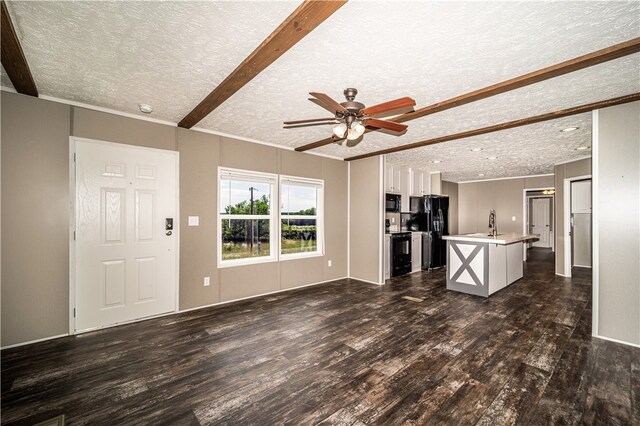 unfurnished living room with beamed ceiling, ceiling fan, dark hardwood / wood-style flooring, and a textured ceiling