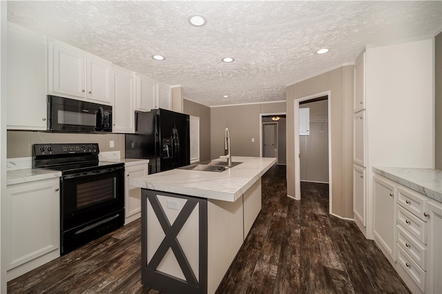 kitchen featuring sink, dark hardwood / wood-style flooring, black appliances, and an island with sink