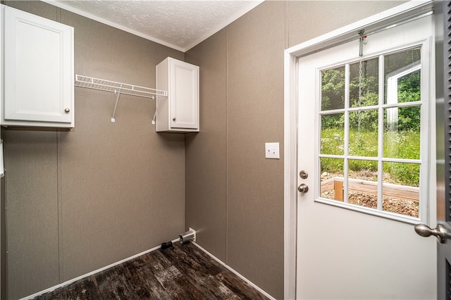 clothes washing area with a textured ceiling and dark wood-type flooring