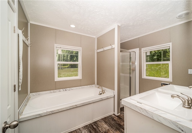 bathroom with a textured ceiling, separate shower and tub, vanity, and hardwood / wood-style floors