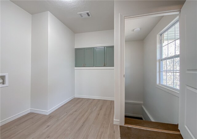 unfurnished room featuring a wealth of natural light and light hardwood / wood-style flooring