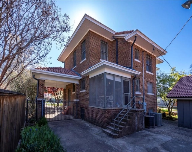 view of front facade featuring central AC unit and a sunroom