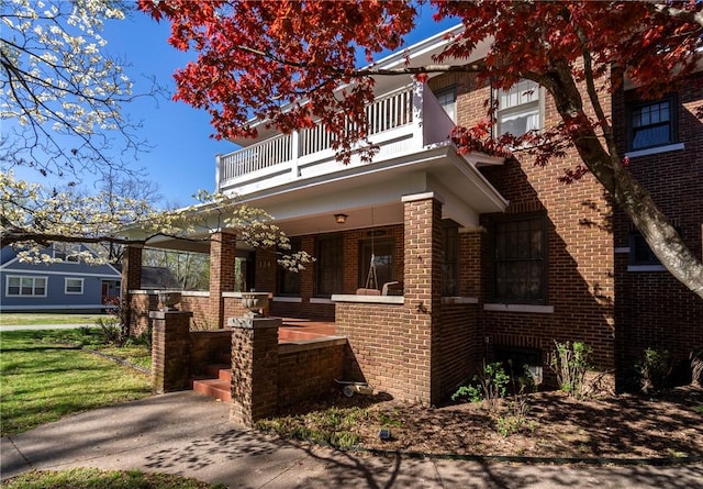 view of front of property featuring a balcony and covered porch