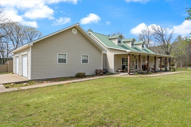 rear view of property with a lawn, a porch, and a garage