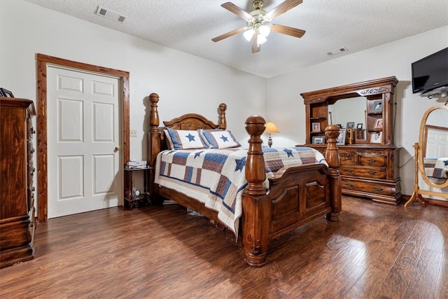 bedroom featuring dark hardwood / wood-style flooring, a textured ceiling, and ceiling fan