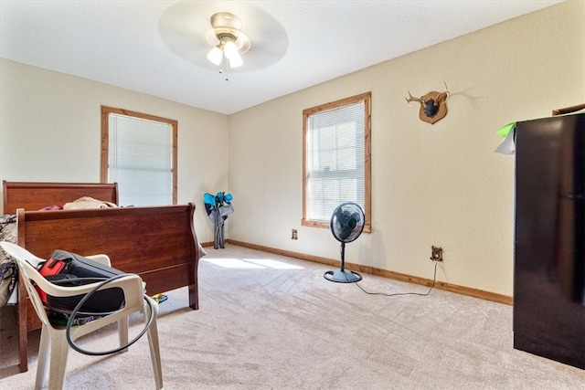 living area with light carpet and ceiling fan