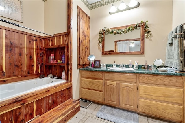 bathroom featuring tile floors, a bathing tub, and vanity