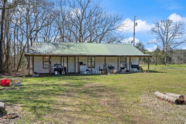 rear view of house with a yard and a porch