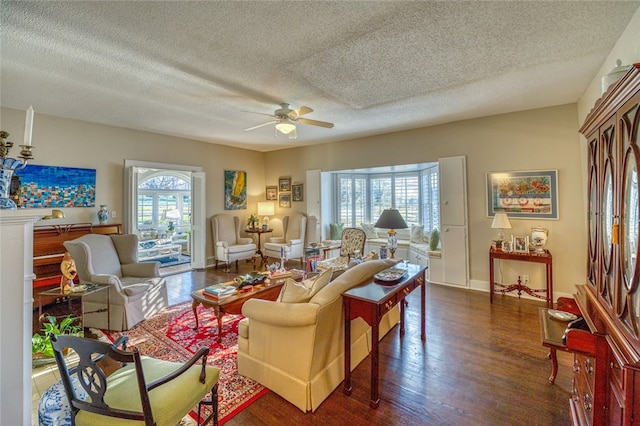 living room with dark hardwood / wood-style flooring, ceiling fan, a textured ceiling, and a wealth of natural light