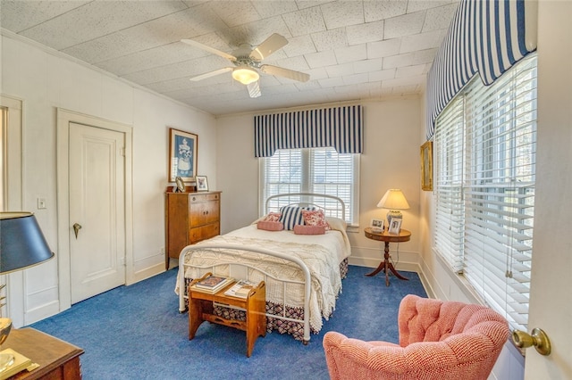 carpeted bedroom with multiple windows and ceiling fan