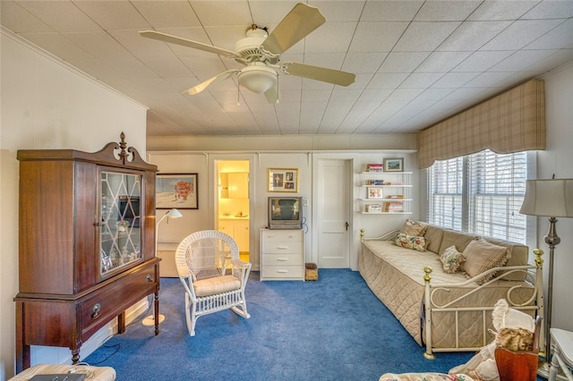 carpeted living room with ceiling fan and ornamental molding