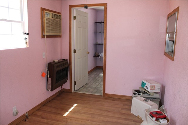 hallway with light wood-type flooring and a wall mounted air conditioner