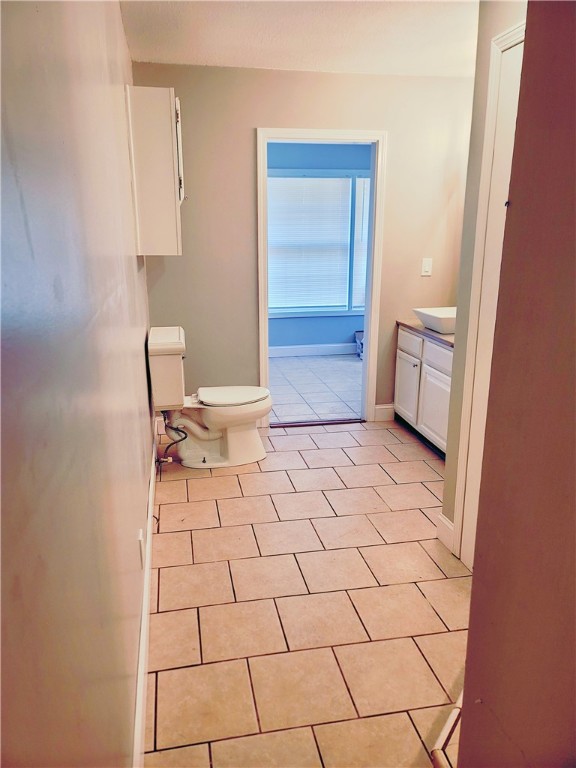 bathroom with tile floors, toilet, and vanity