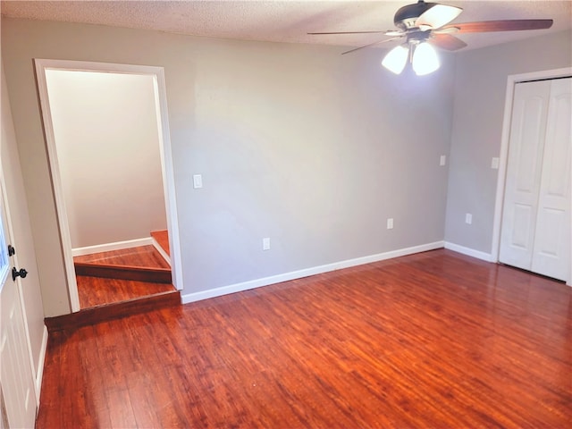 unfurnished room with a textured ceiling, dark hardwood / wood-style flooring, and ceiling fan